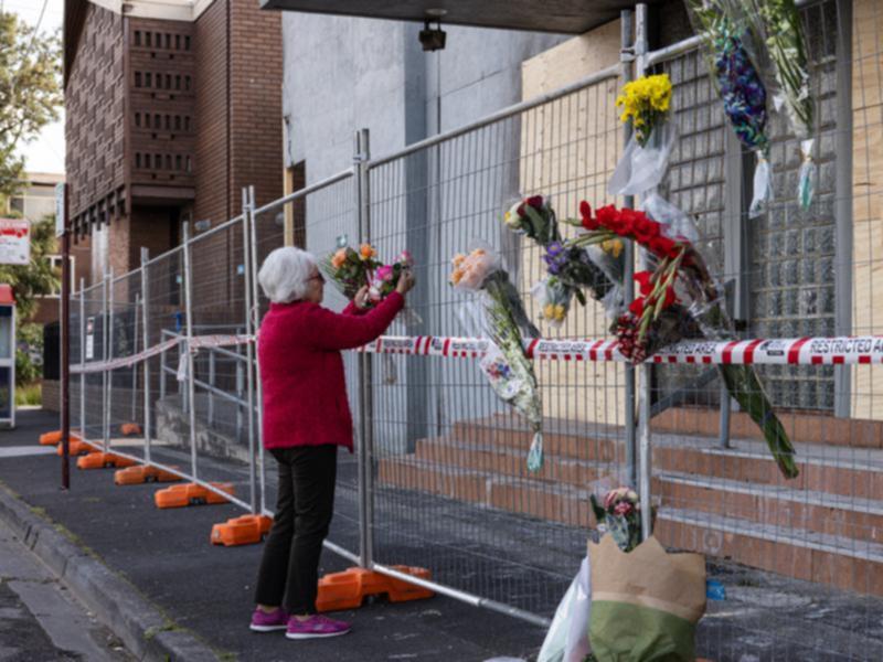 A woman leaves flowers at the synagogue site. 