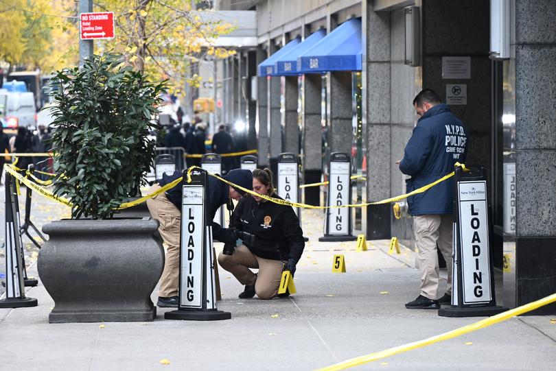 Police officers investigate the scene where UnitedHealthcare CEO Brian Thompson was fatally shot in Midtown Manhattan near a hotel on 54th Street between 6th and 7th Avenues on December 04, 2024 in New York, United States. 