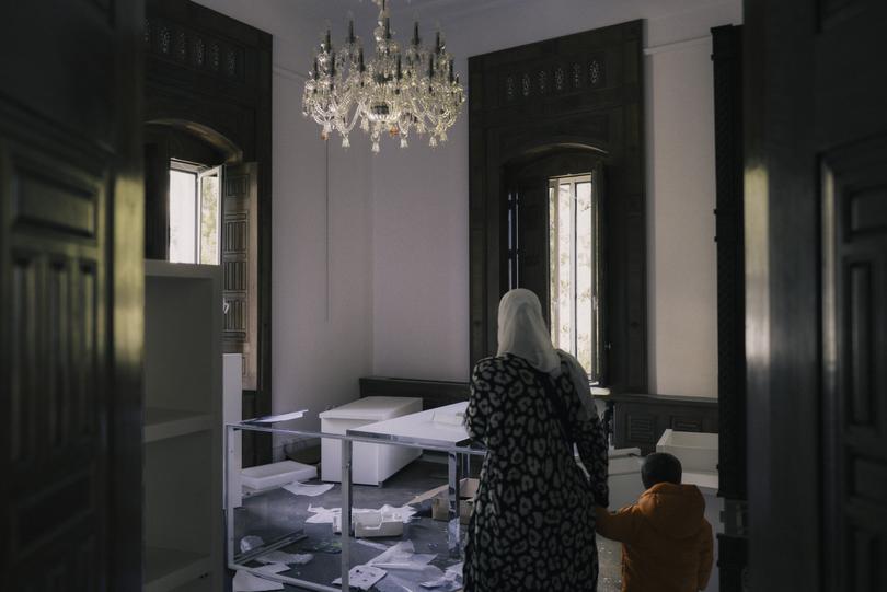 Civilians inside a looted palace in Damascus on Monday.