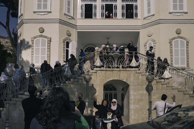 Civilians gather at a looted palace.