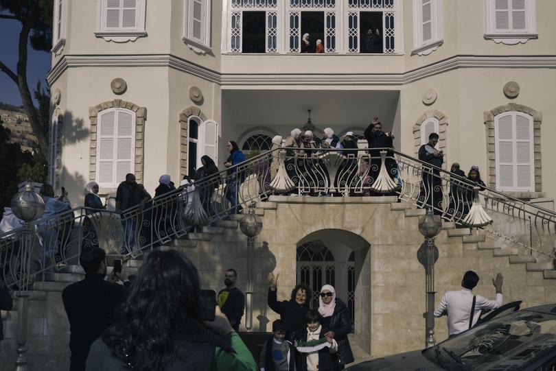 Civilians gather at a looted palace. 