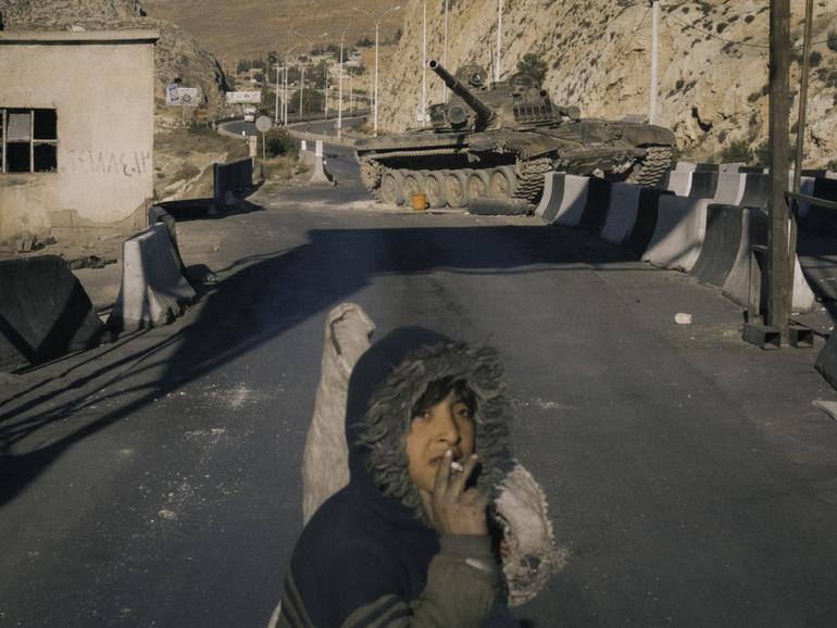 A destroyed army checkpoint and abandoned tank.