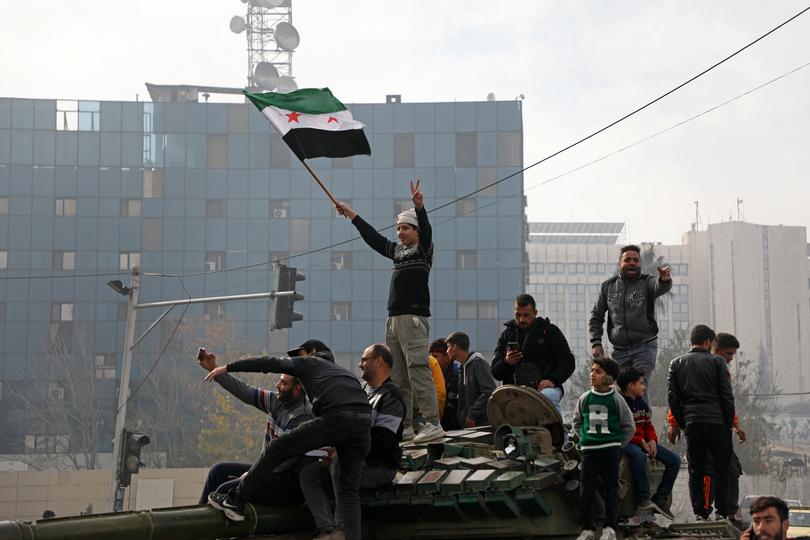 People react to the fall of Syrian regime in Umayyad Square on December 8.