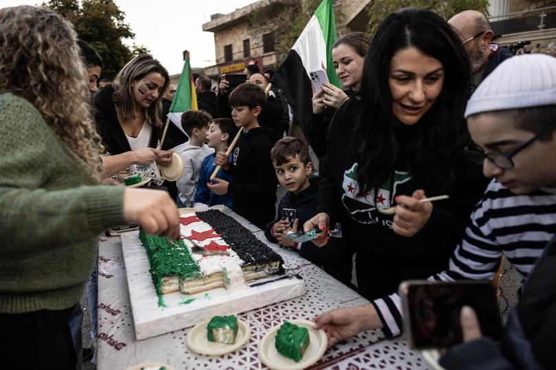 Residents of the Druze village of Majdal Shams in the Israeli-occupied Golan Heights carry a cake decorated with the Syrian opposition flag during a celebration on Monday. 