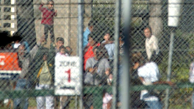 Men and women detainees held at Villawood are separated by a fence.