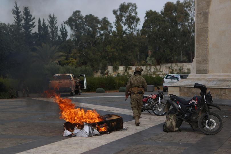 The burning coffin of Syria's late president Hafez al-Assad was dragged outside his mausoleum.