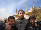 Syrian opposition forces help US citizen Travis Timmerman, centre, who was found by residents in the town of Dhiyabiya.