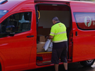 A delivery driver drops off a parcel.