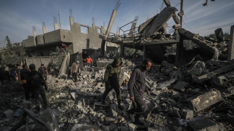 People inspect a destroyed house in Al Nusairat refugee camp in central Gaza Strip. 