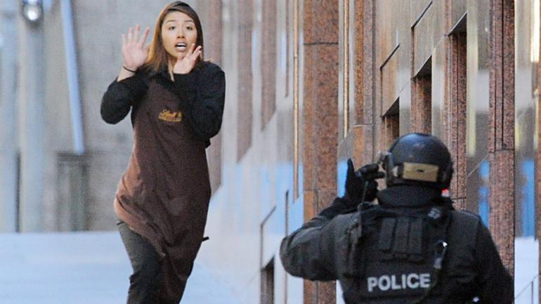 **FILE** A Dec. 15, 2014 file image of Sydney Siege hostage Elly Chen runs from the Lindt Chocolate cafe in Martin Place, Sydney. The long-running inquest into the deadly Lindt cafe siege has wrapped up its public hearings in Sydney, with NSW Police Commissioner Andrew Scipione the last witness to give evidence. (AAP Image/Joel Carrett) NO ARCHIVING