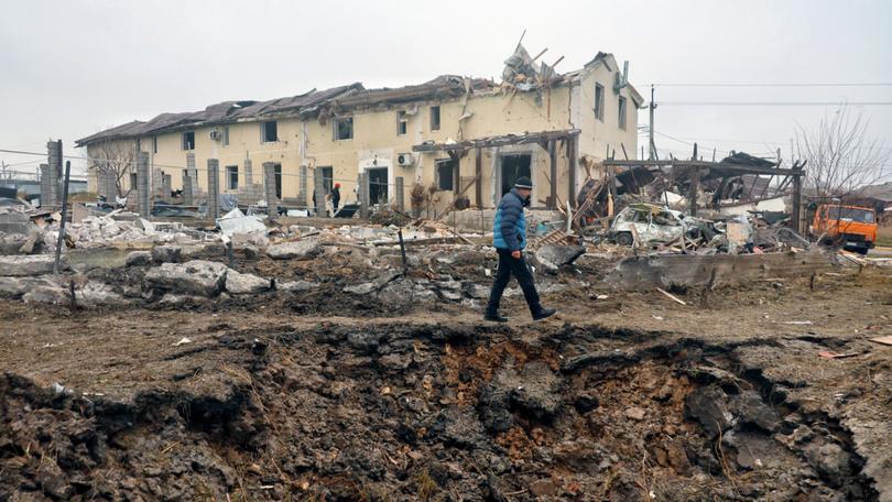 A man walks on the edge of the shell crater caused by a Russian missile strike, Odesa region, southern Ukraine.