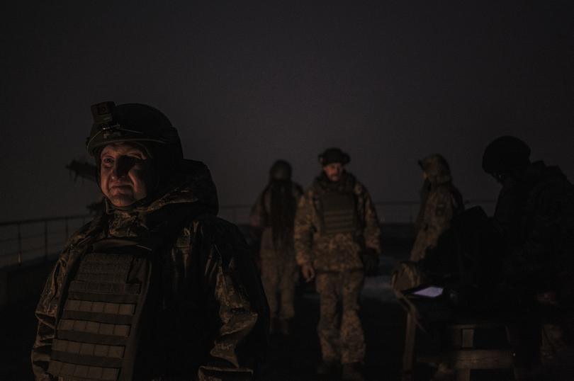 Members of a volunteer air defence unit check radar on a tablet for approaching Shahed drones on a roof in central Kyiv.