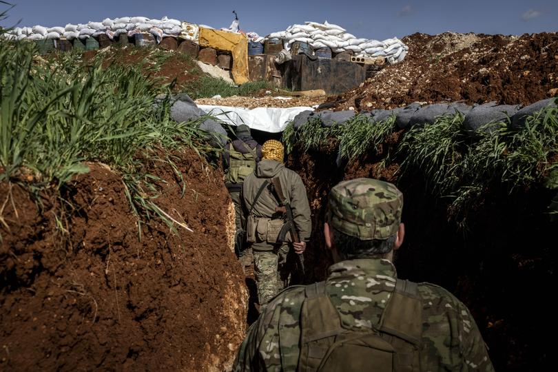  Fighters for the militant group Hayat Tahrir al-Sham wend their way through a trench on the front lines near the town of Maaret al-Nasaan, in Idlib Province, Syria, on March 25, 2021. The Islamist rebels who ousted Syria’s dictator ran a pragmatic and disciplined administration in the territory they controlled. They also jailed their critics. 