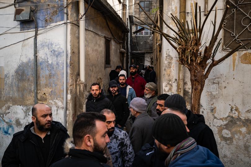 Friends and family members of Heybi gather outside his home in Masyaf on Sunday after he was found dead. 