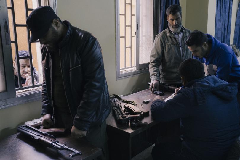 Members of the new security forces collect surrendered weapons from former members of the Syrian regime's security forces. 