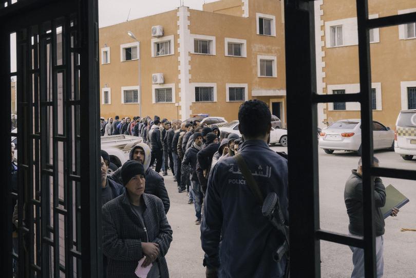 Former members of the Syrian security forces line up at a police station in Latakia on Monday to take part in the “reconciliation” process. 