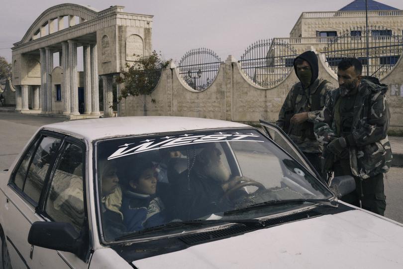 Sheikh Ahmed Banawi and his family stop at an HTS checkpoint on the way out of al-Hakeem on Monday. The family was leaving the village in fear of reprisals from militants, hoping to make it to Turkey.