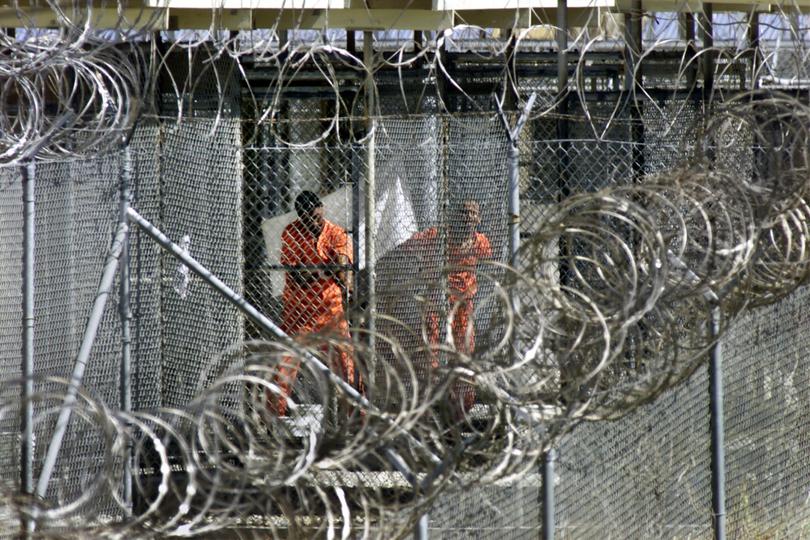 Dressed in bright orange overalls, al-Qaida and Taliban prisoners wash before midday prayers at Camp X-Ray.