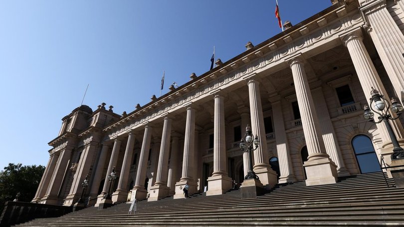About 20 masked men allegedly posed with offensive signs outside Victorian parliament.