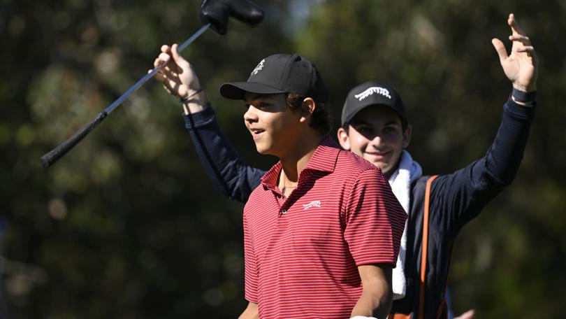 Charlie Woods, front, and his caddie Luke Wise react after his hole-in-one on the fourth hole during the final round of the PNC Championship.