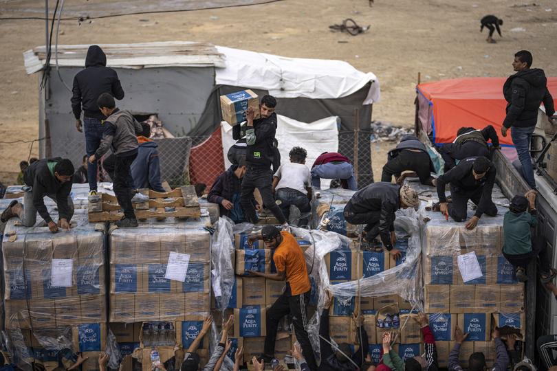 Palestinians grab humanitarian aid from a truck as it crossed into the Gaza Strip in Rafah.