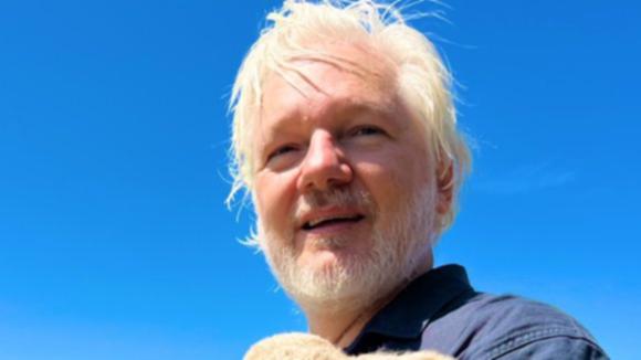 Julian Assange clutches a lamb in a picture posted alongside a Christmas message on social media.