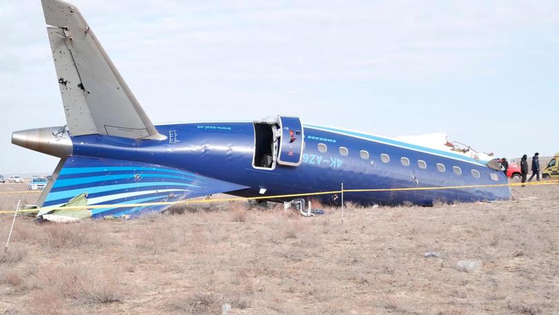 The wreckage of the plane with holes visible in the fuselage. 