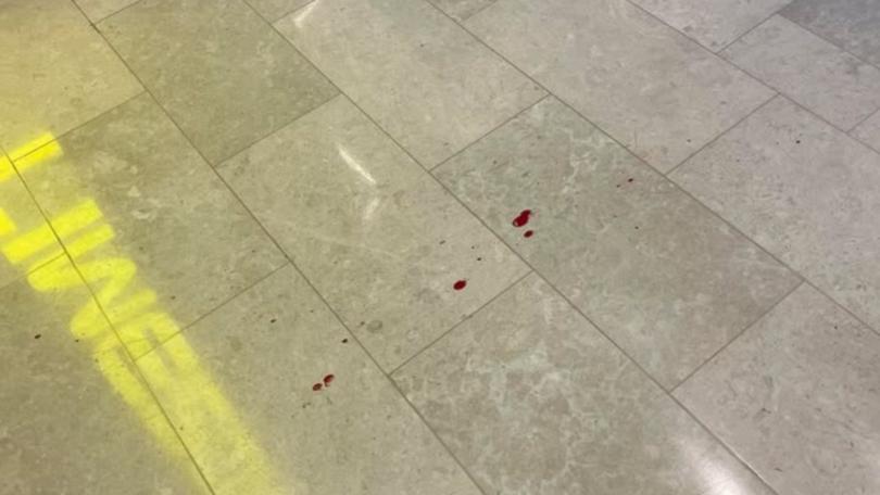 Drops of blood on the floor inside the shopping centre.