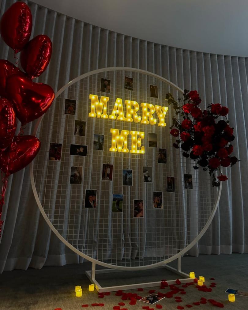 Photos surrounded the MARRY ME sign. 