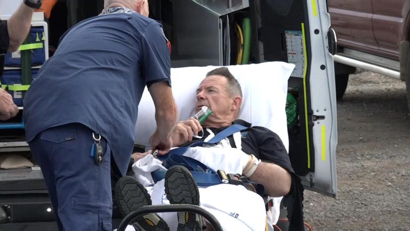 A sailor with a dislocated shoulder was escorted down the dock by paramedics with his arm in a sling before he was placed onto a stretcher and given a green whistle for the pain.