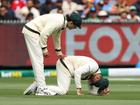 Sam Konstas of Australia checks on Usman Khawaja of Australia after he caught his knee in the turf during day three.