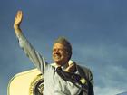 Former US President Jimmy Carter waving atop the steps of Air Force One in 1977.