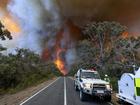 Country Fire Authority personnel watch as smoke billows from an out of control bushfire in the Grampians National park, in Victoria state, Australia.