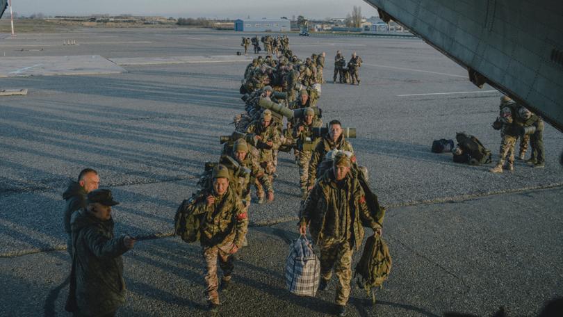 Russian troops board a military aircraft in Grozny, Russia, Dec. 4, 2023. From murder suspects to immigrants to a former Olympic gold medallist, Russia pressures those it thinks should fight in Ukraine.