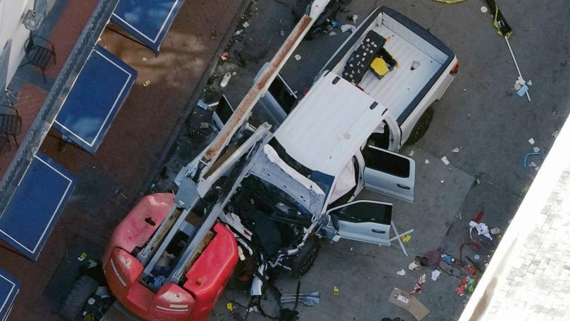 A black flag with white lettering lies on the ground rolled up behind a pickup truck that a man drove into a crowd on Bourbon Street in New Orleans, killing and injuring a number of people, early Wednesday morning, Jan. 1, 2025. 