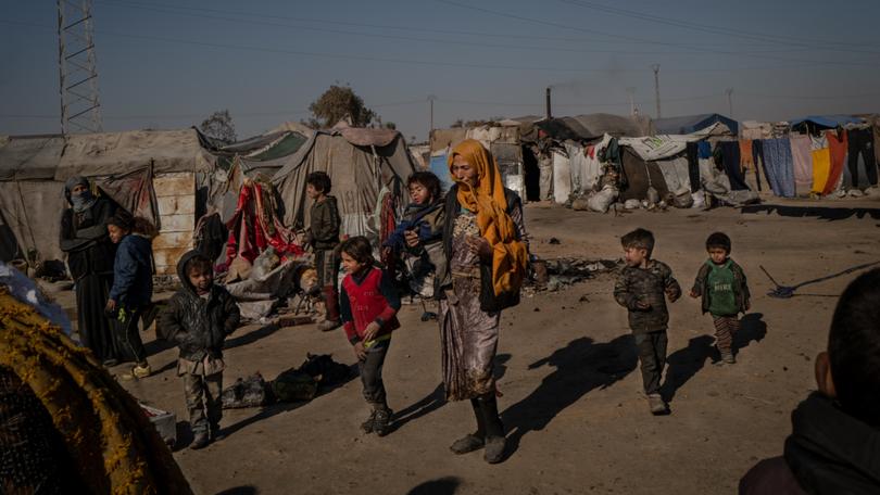 People walk through the Sahel al Banat camp for internally displaced people in Raqqa governorate in Syria in 2022. MUST CREDIT: Nicole Tung for The Washington Post