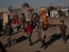 People walk through the Sahel al Banat camp for internally displaced people in Raqqa governorate in Syria in 2022. MUST CREDIT: Nicole Tung for The Washington Post