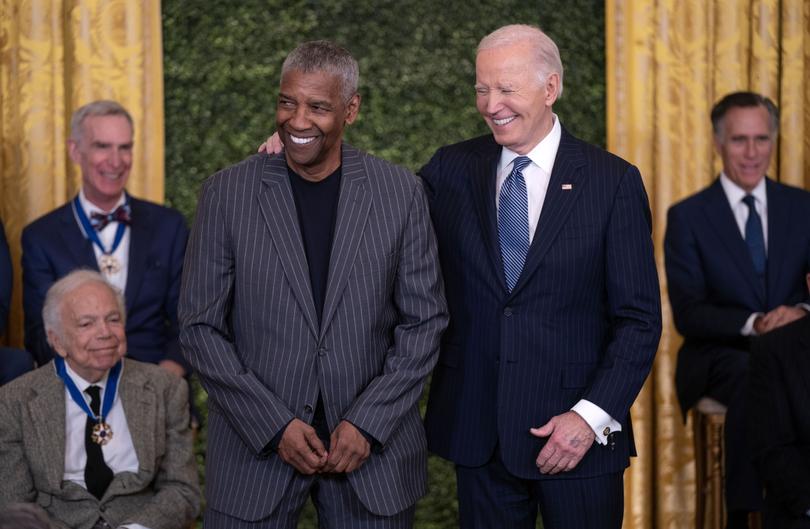 President Joe Biden (R) presents actor, producer, and director Denzel Washington with the Presidential Medal of Freedom.