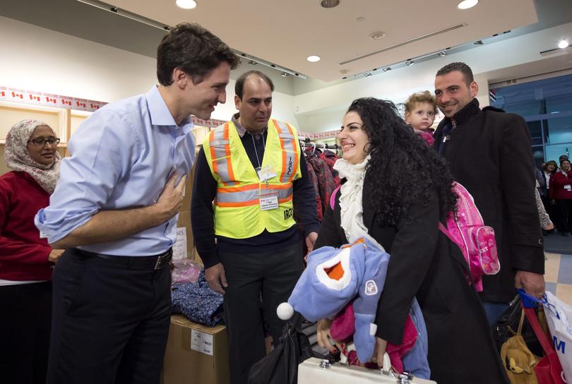 Prime Minister Justin Trudeau, left, greets Syrian refugees Georgina Zires, centre, Madeleine Jamkossian, second right, and her father Kevork Jamkossian, at Pearson International airport in late 2015. 