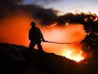 A Los Angeles County firefighter battles the Palisades wildfire.