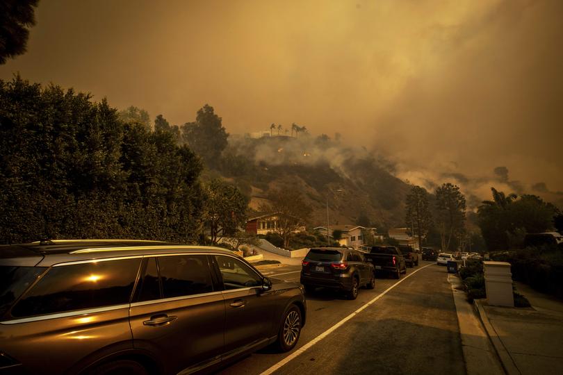 A line of vehicles crowds the road as residents flee from the Palisades Fire.