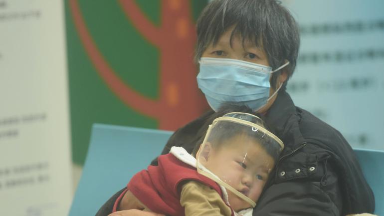 A child, accompanied by their parents, sees a doctor at a pediatric department of a hospital in Hangzhou.