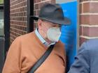 Ex-priest Guy Norman Hartcher tried to hide his face behind a hat and face mask outside court.