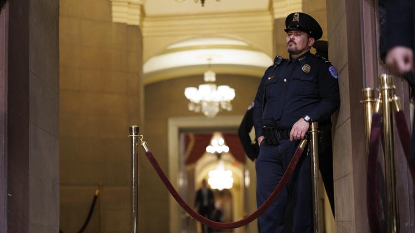 Police officers look on into the Rotunda at the US Capitol building.