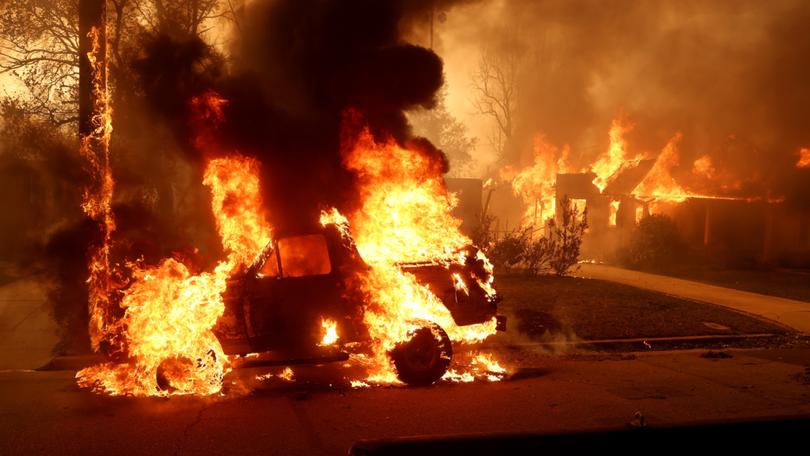 A car burns as the Eaton Fire moves through Altadena, California. 