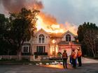 Authorities say two people have been arrested for looting. Pictured: Firefighters survey the damage caused by the fires. 