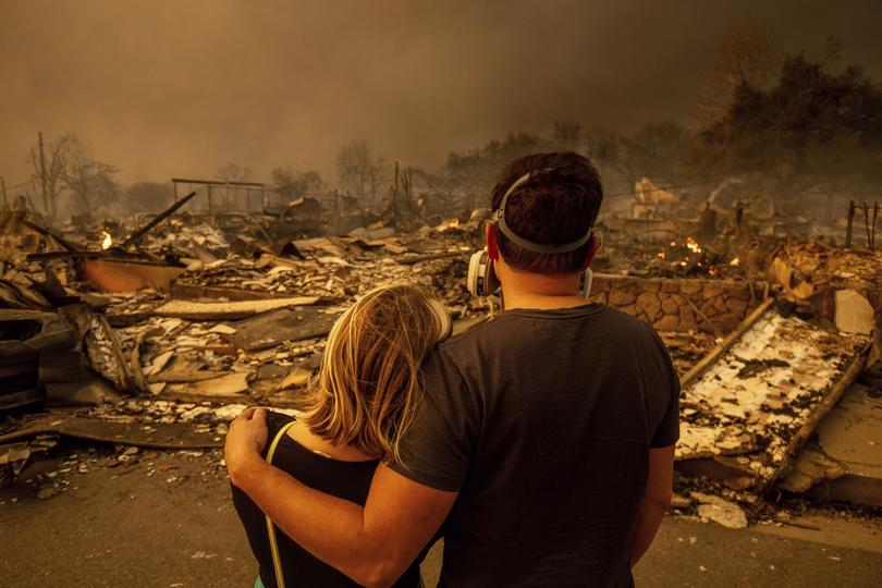 Megan Mantia, left, and her boyfriend Thomas, only first game given, return to Mantia's fire-damaged home after the Eaton Fire swept through the area, Wednesday, Jan. 8, 2025, in Altadena, Calif. 