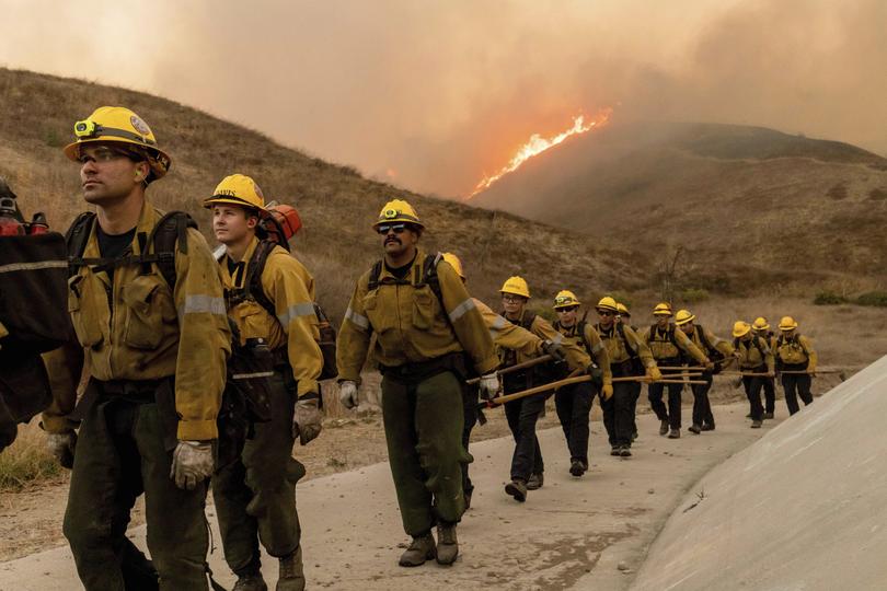 Fire crews walk as they battle the Kenneth Fire in the West Hills section of Los Angeles.