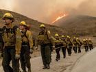 Fire crews walk as they battle the Kenneth Fire in the West Hills section of Los Angeles, Thursday, Jan. 9, 2025. (AP Photo/Ethan Swope)