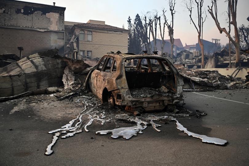 Melted metal from a charred vehicle is seen on the pavement after the passage of the Palisades Fire in Pacific Palisades, California, on January 8, 2025.